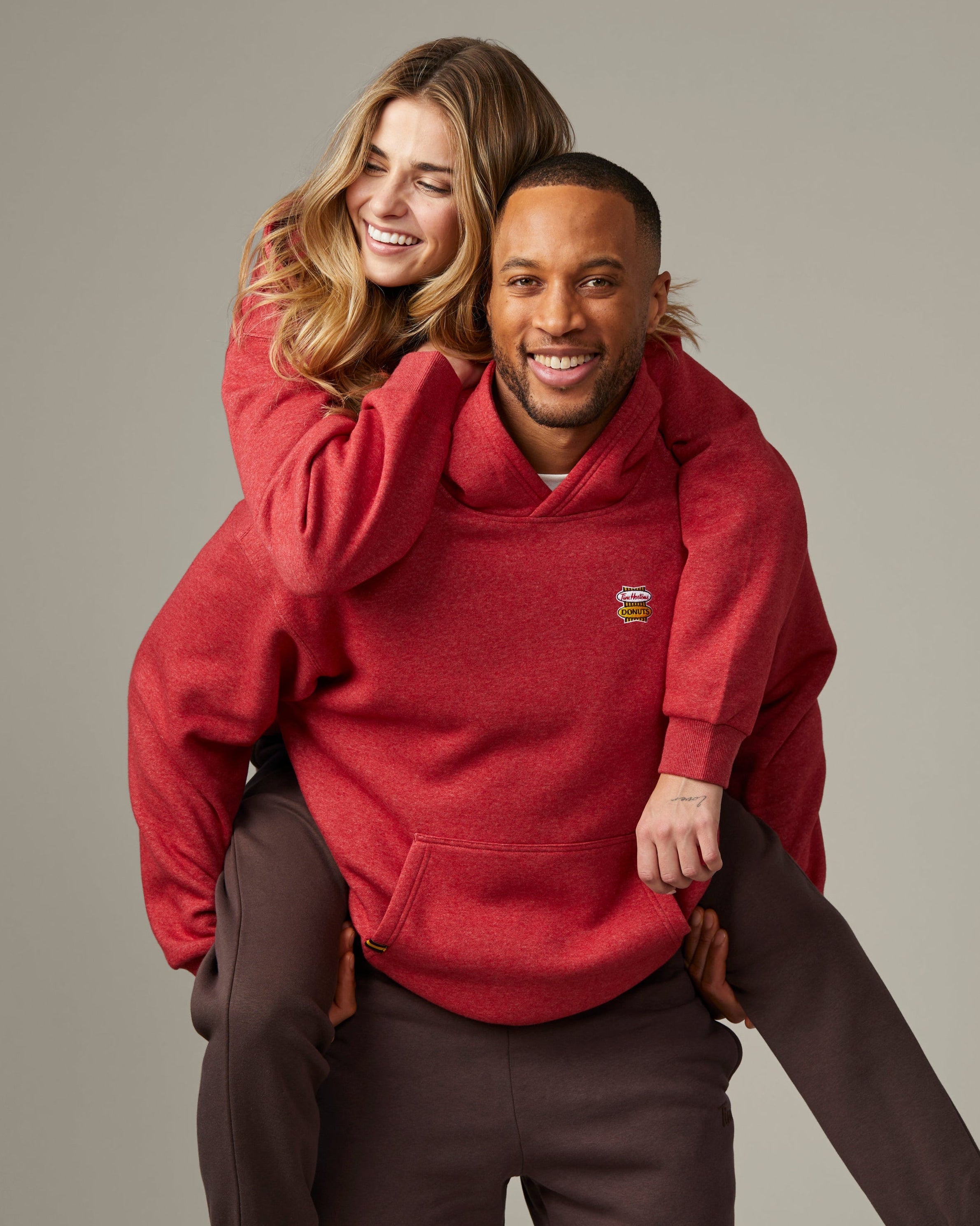 Red marl unisex hoodie featuring retro Tim Hortons logo on chest | Chandail à capuchon unisexe rouge chiné avec logo Tim Hortons rétro à l’avant.
