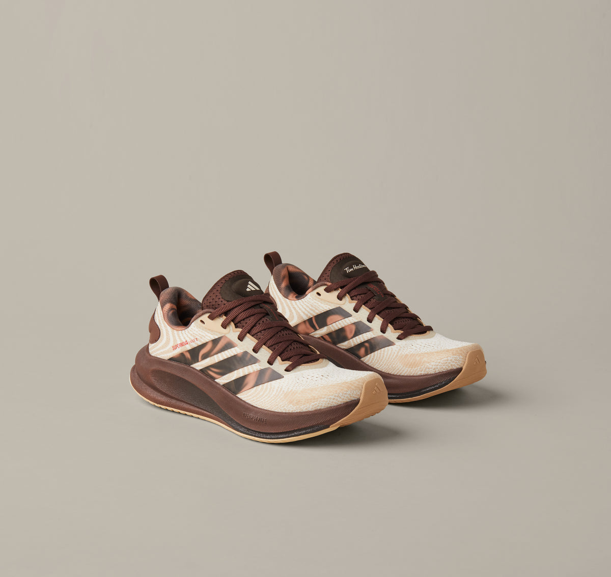Women’s adidas® Supernova Ease running shoes in cream and coffee-brown shades with patterned 3-Stripes and Tim Hortons details. - Image #1