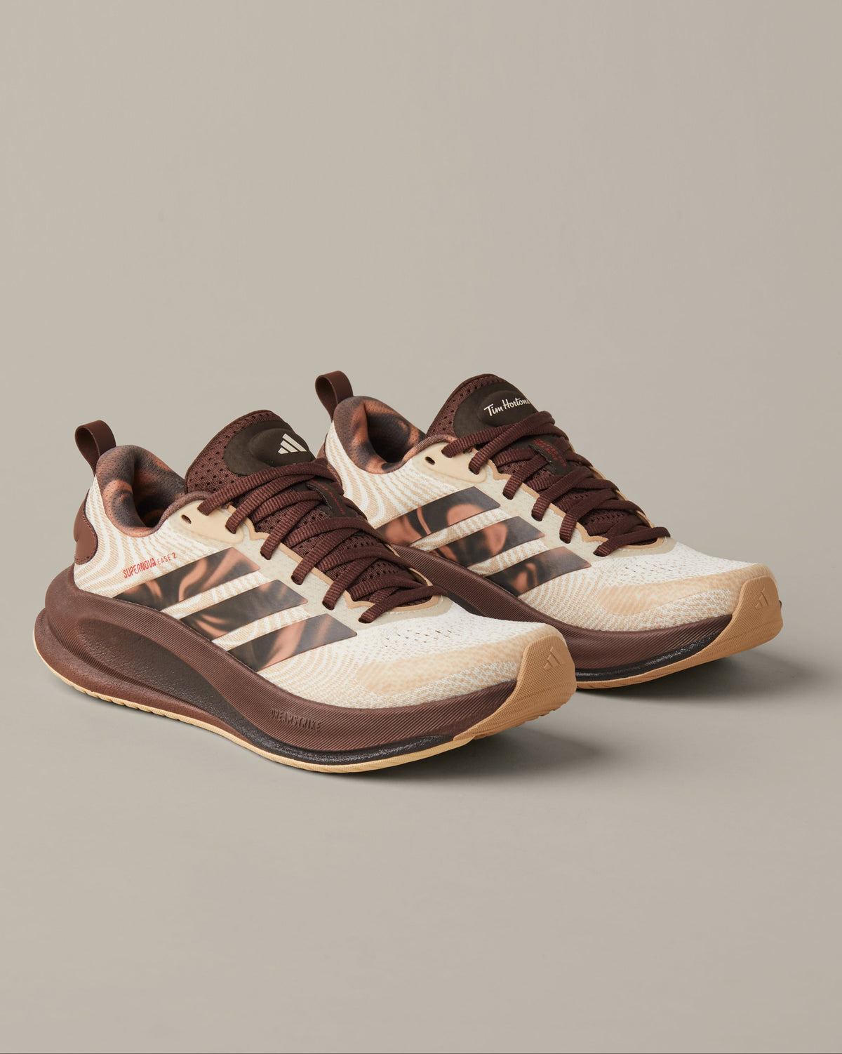 Women’s adidas® Supernova Ease running shoes in cream and coffee-brown shades with patterned 3-Stripes and Tim Hortons details. - Image #1