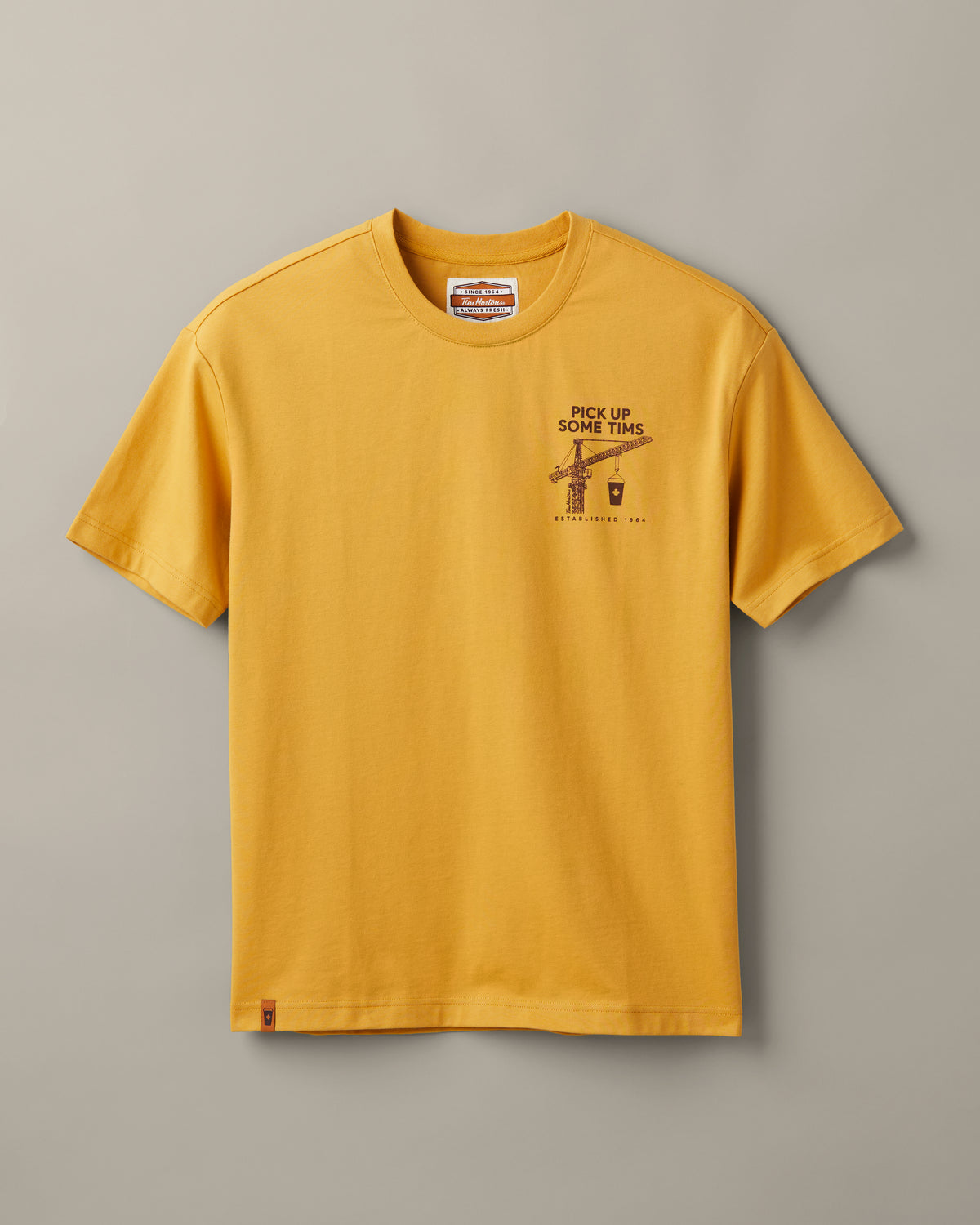 Ochre Tim Hortons crew-neck T-shirt with a small Pick Up Some Tims crane and coffee cup graphic on the chest. | T-shirt Tim Hortons ocre à encolure ronde avec une petite illustration de grue et de gobelet de café « Prendre son Tim » sur la poitrine. - Image #3