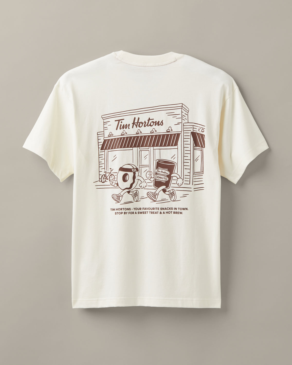 Cream unisex T-shirt featuring coffee-and-donut characters running past a classic Tim Hortons restaurant. - Image #2