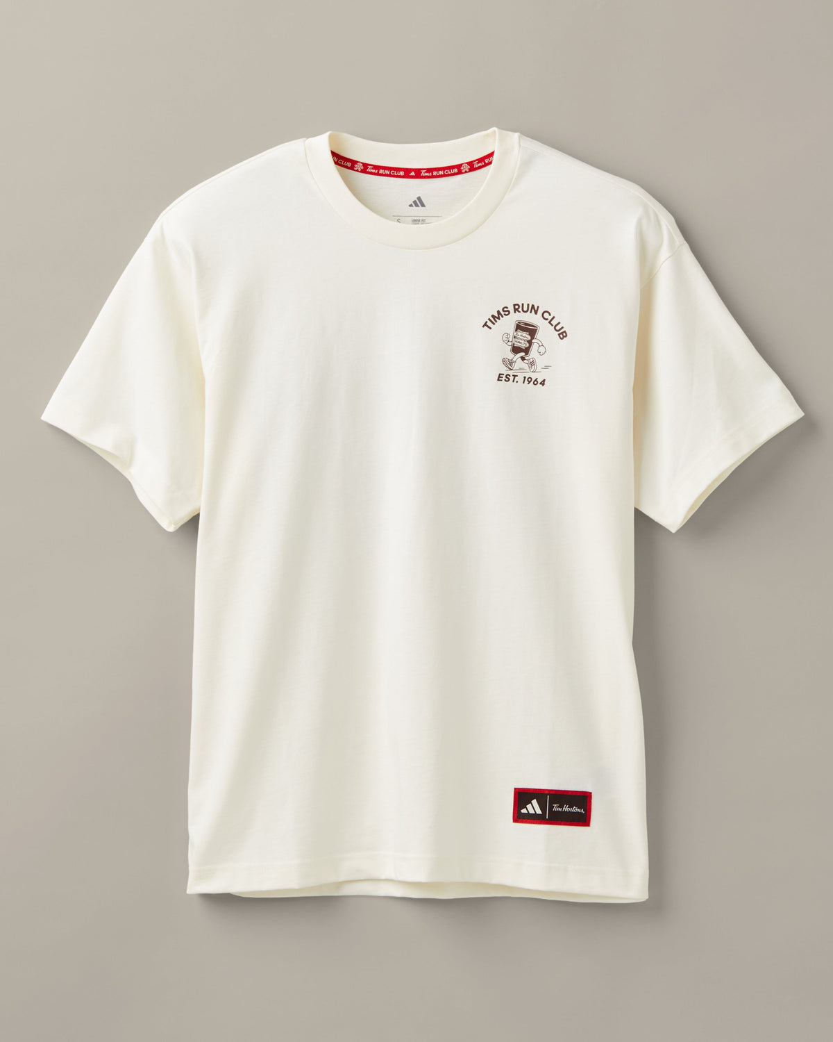 Cream unisex T-shirt featuring coffee-and-donut characters running past a classic Tim Hortons restaurant. - Image #2
