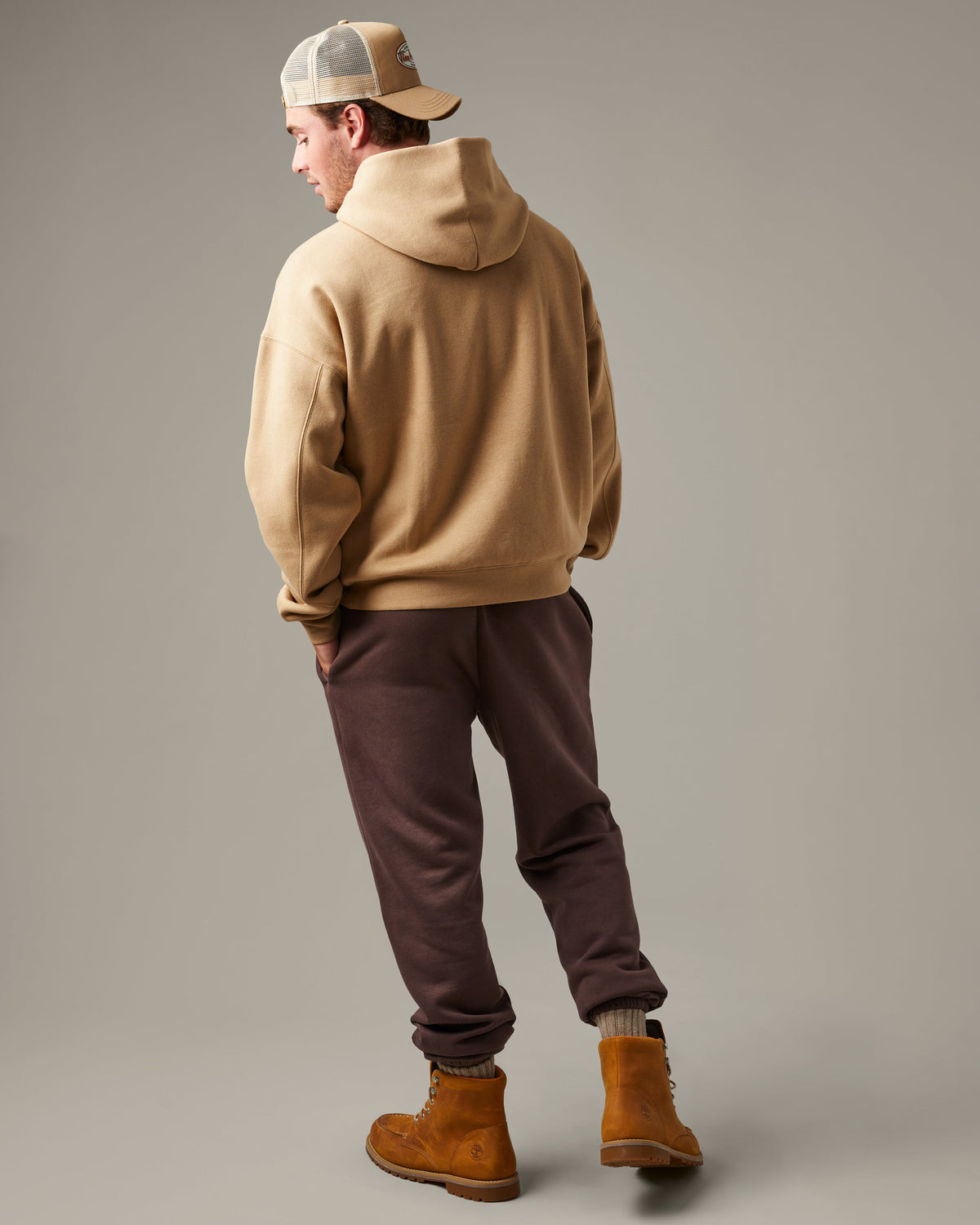 Beige Tim Hortons pullover hoodie with a kangaroo pocket and small A Friend Along the Way delivery truck graphic on the chest. | Chandail à capuchon Tim Hortons beige avec poche kangourou et petite illustration de camion de livraison « Un ami sur la route » sur la poitrine. - Image #2