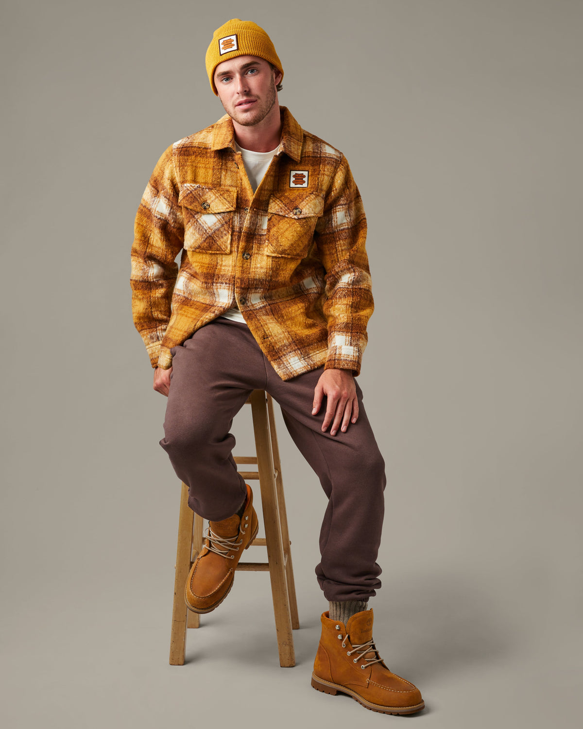 Yellow, brown, and cream plaid Tim Hortons shacket with a button front, two flap chest pockets, and a small logo patch. | Surchemise Tim Hortons à carreaux jaunes, bruns et crème, avec fermeture à bouton sur le devant, deux poches poitrine à rabat et un petit écusson à logo. - Image #1
