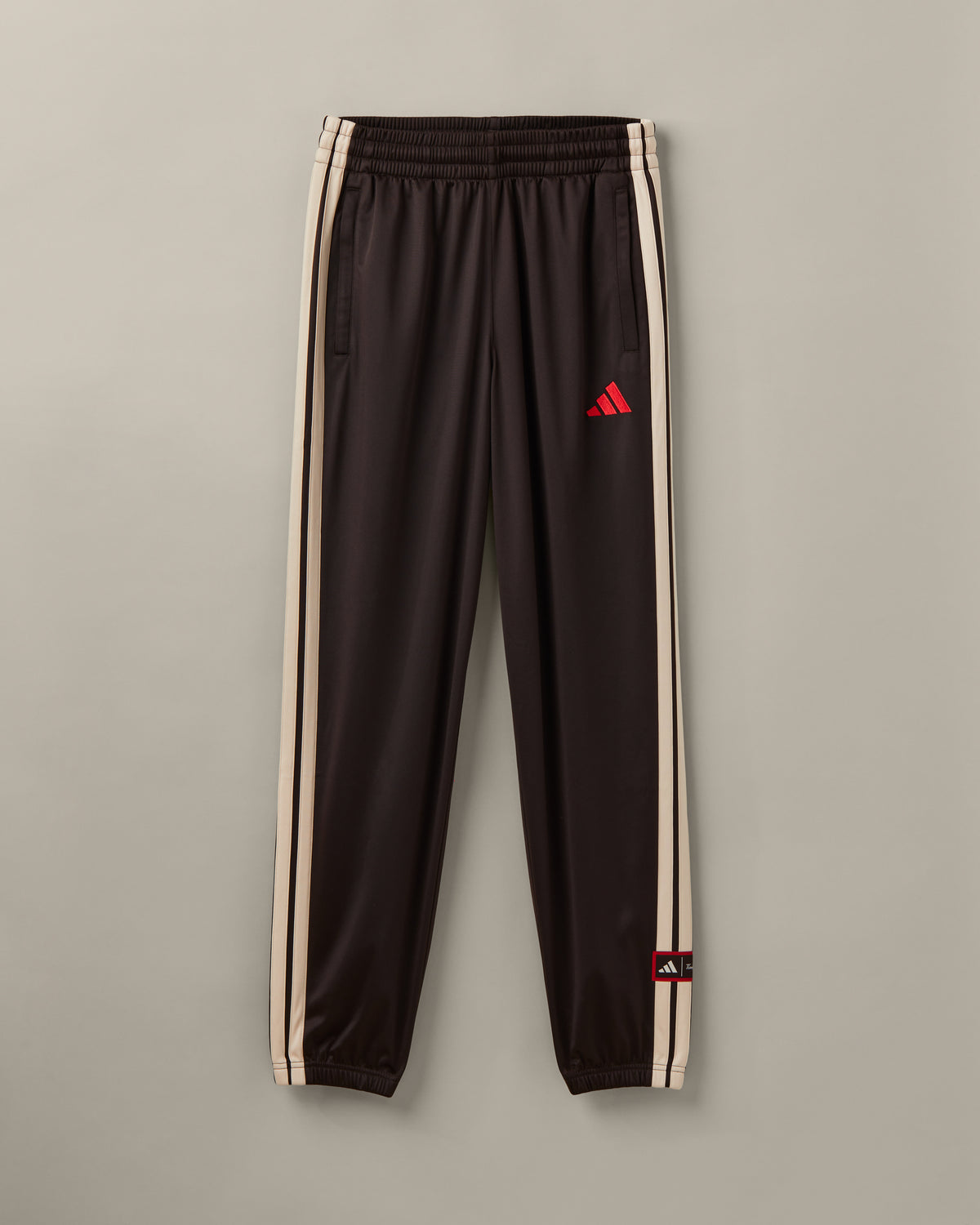 Men’s espresso-brown adidas® track pants with cream 3-Stripes and adidas® x Tim Hortons collaboration details. - Image #1