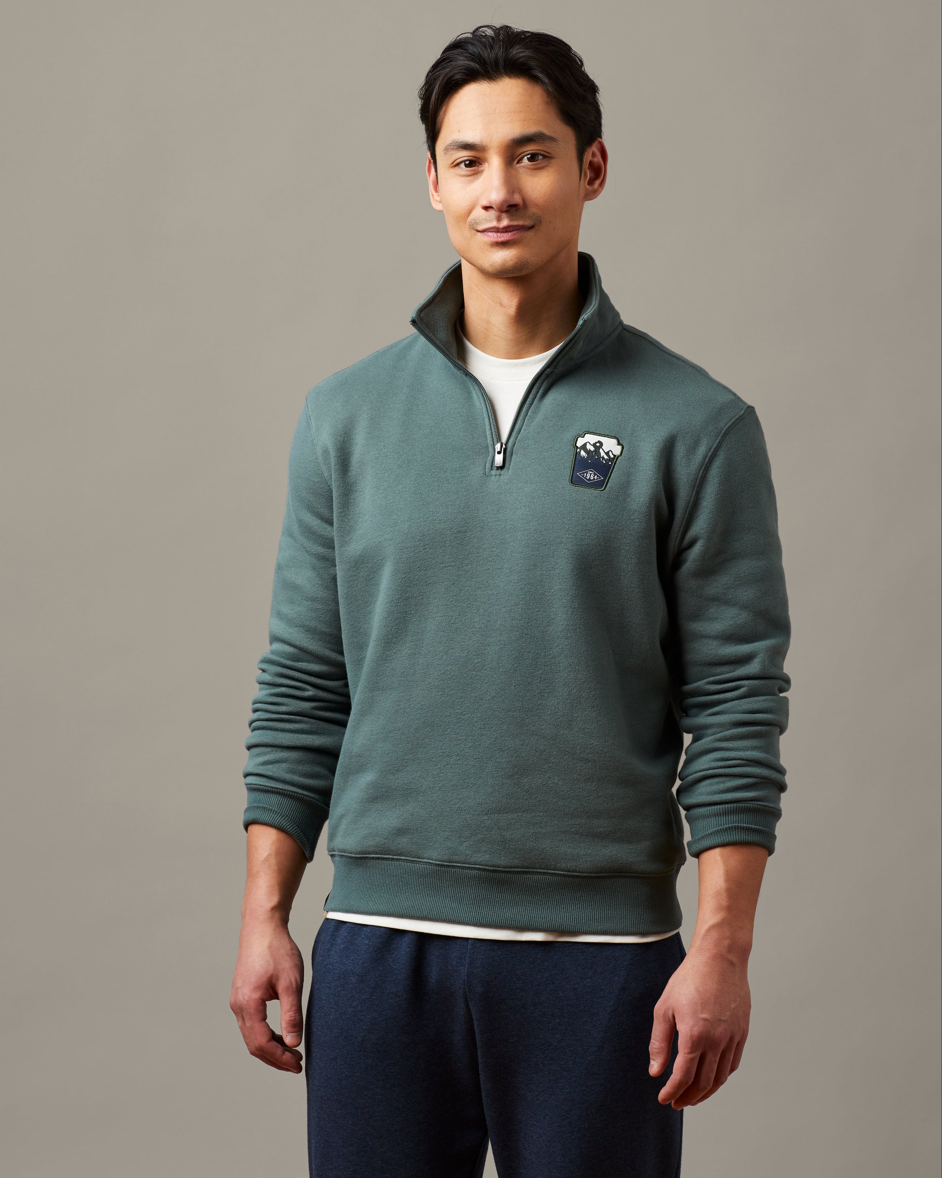 Forest green unisex quarter zip featuring embroidered Tims cup design | Chandail à glissière 1/4 unisexe vert forêt avec motif brodé représentant un gobelet Tim Hortons. - Image #1