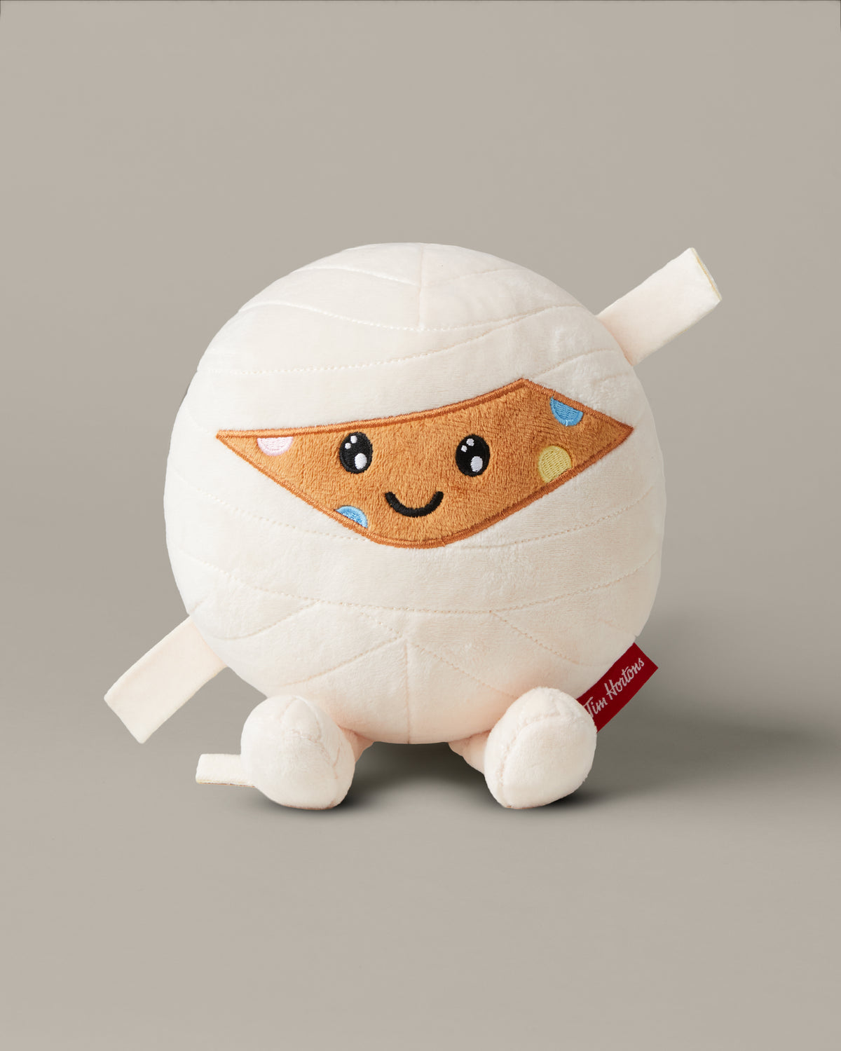 Timbits® Mummy plush with white wrapping, an embroidered face and black-and-white striped legs. | Peluche momie TimbitsMD avec bandelettes blanches, visage brodé et jambes rayées noir et blanc. - Image #3