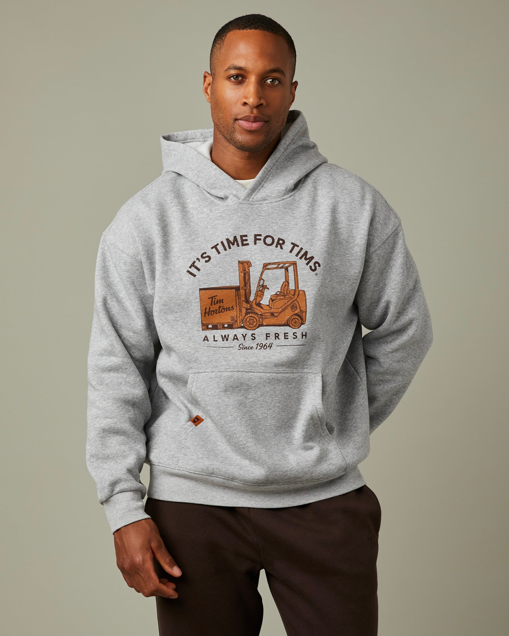 Grey hoodie with “It’s Time for Tims” graphic featuring a forklift carrying Tim Hortons coffee | Chandail à capuchon gris avec un logo « It’s Time for Tims » montrant un chariot élévateur transportant un café Tim Hortons - Image #1